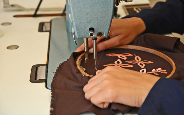 Broderie machine d'un motif sur un tissu maintenu dans un cadre à broder